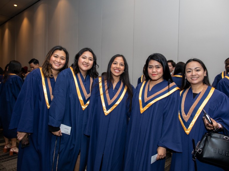 Five graduates smile for camera