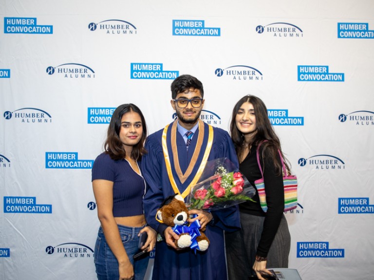 Graduate takes photo with two guests