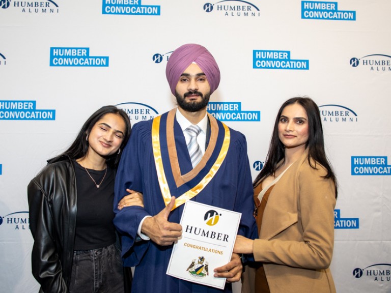 Graduate takes photo with two guests