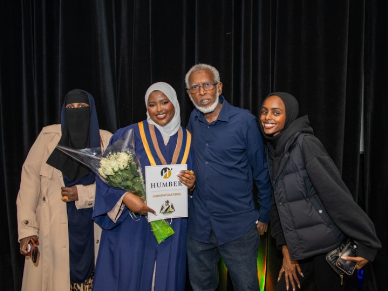 Graduate takes photo with three family members