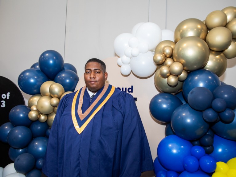 Graduate takes photo in front of balloons