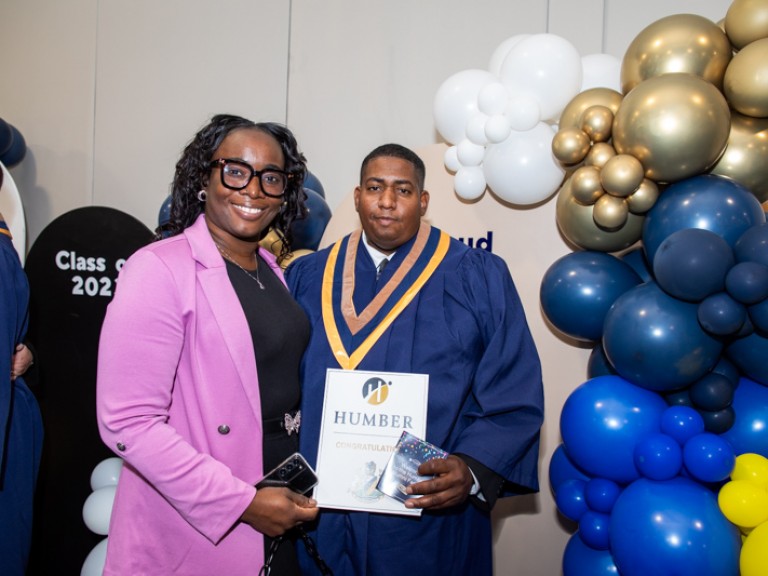 Graduate poses for photo with ceremony guest