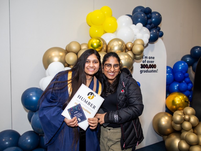 Graduate takes photo with ceremony guest