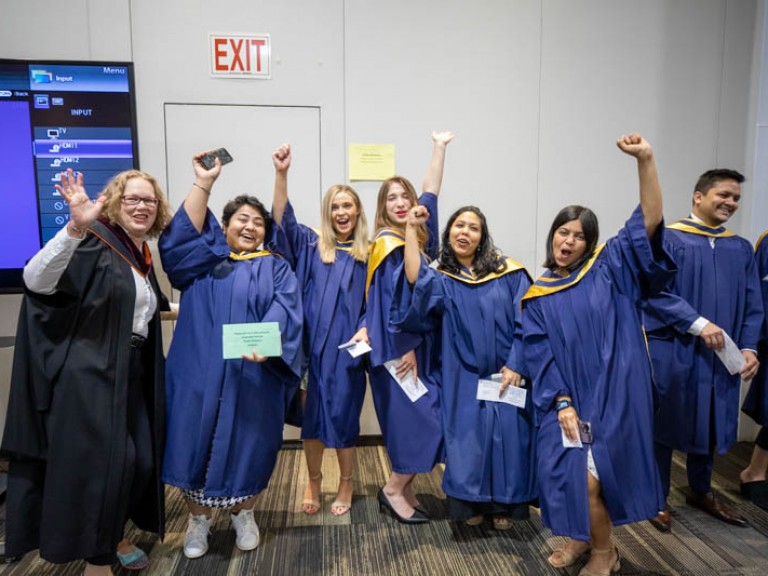 Group of female graduates raising their arms in celebration