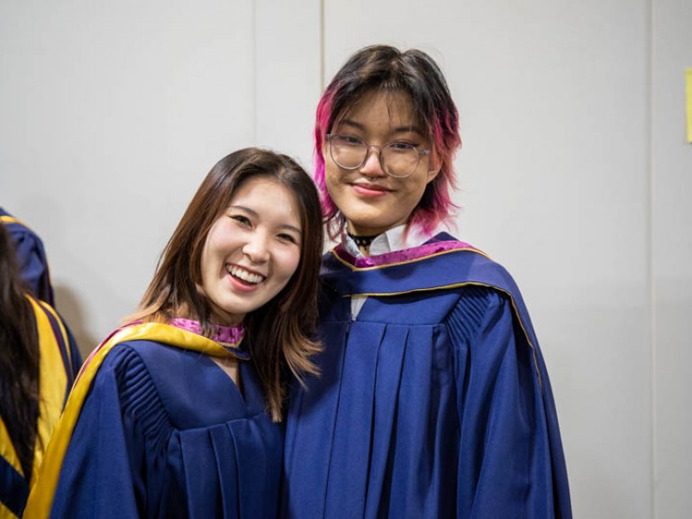 Two graduates smiling for photo