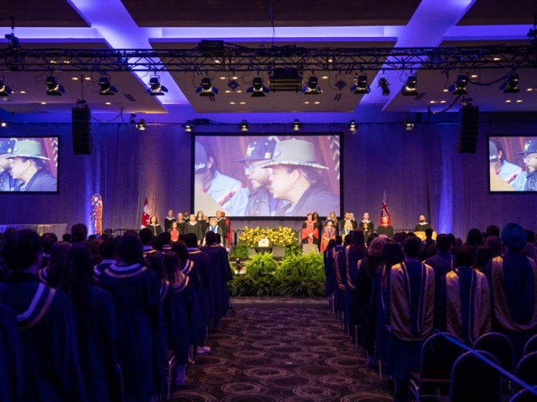 Faculty standing on stage