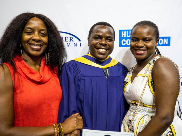 Graduate taking photo with two family members