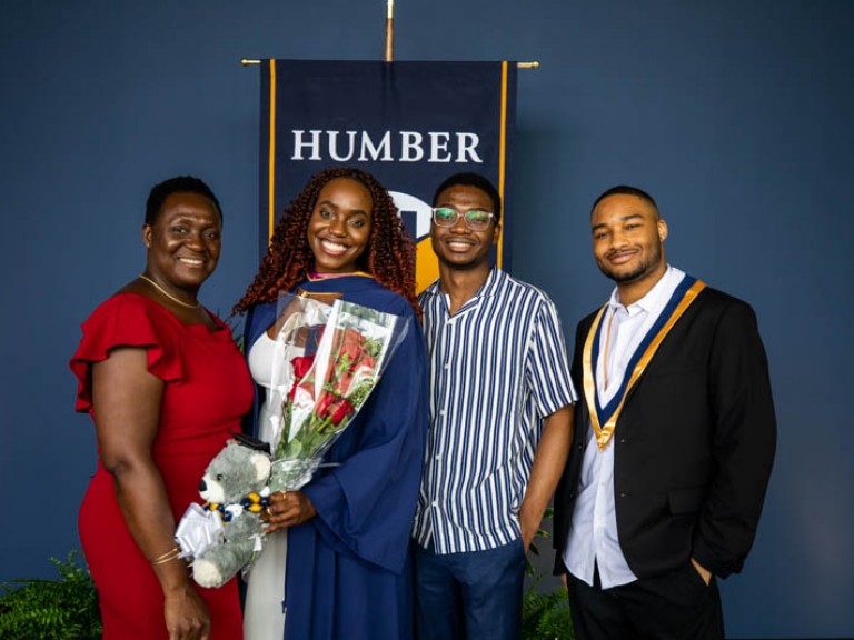 Graduate holding roses smiling with family