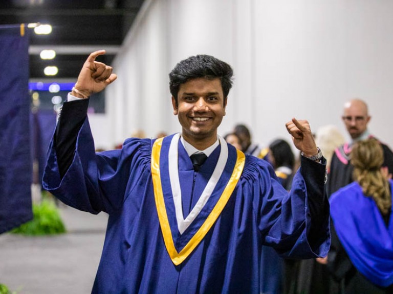 Graduate raising hands in celebration