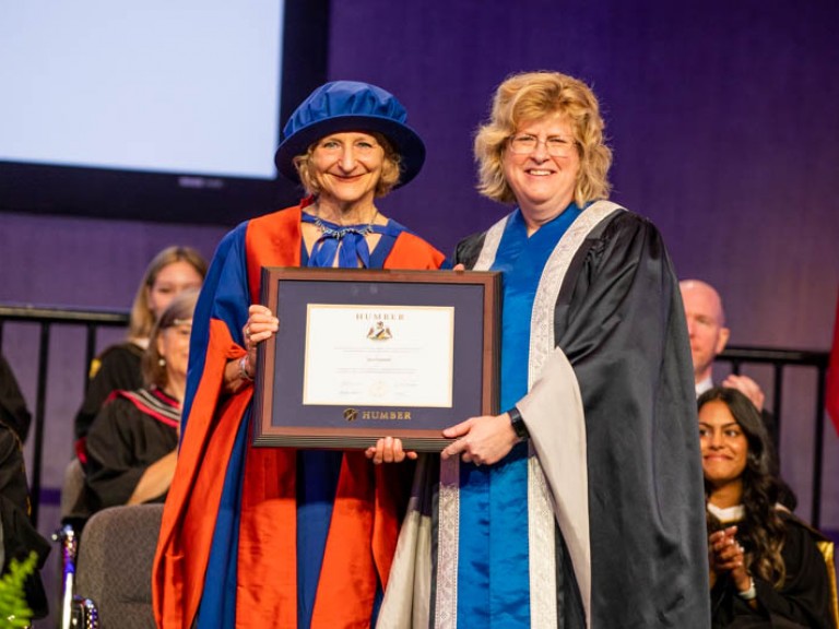 Ann Marie Vaughan and Sara Diamond holding framed degree smiling for photo