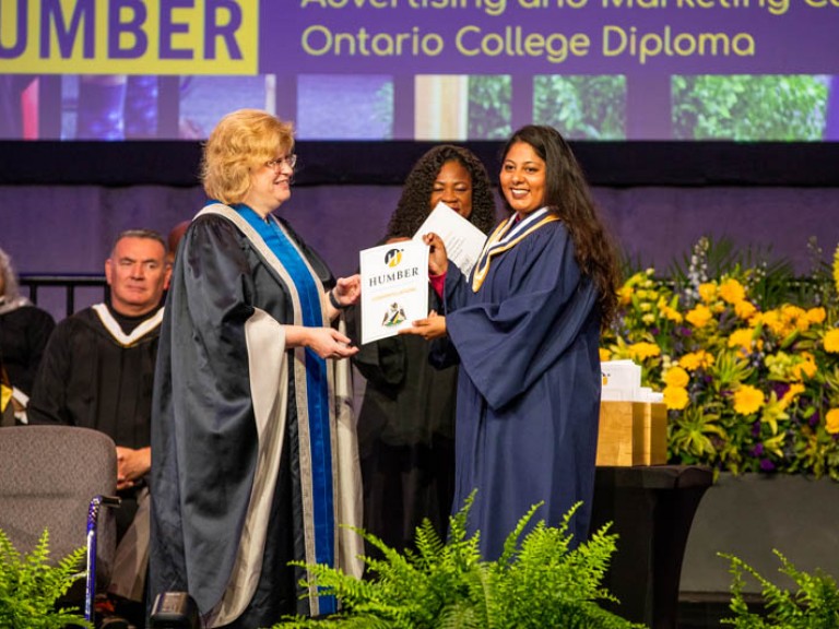 Graduate accepting certificate from Humber president on stage