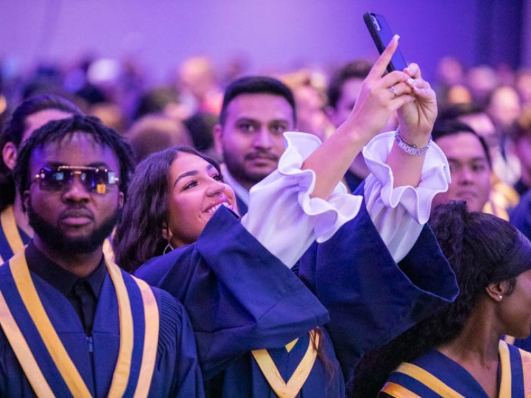 Graduate in audience taking a selfie