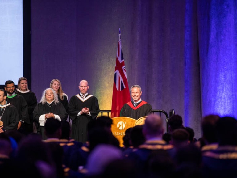 Person speaking at Humber podium on stage