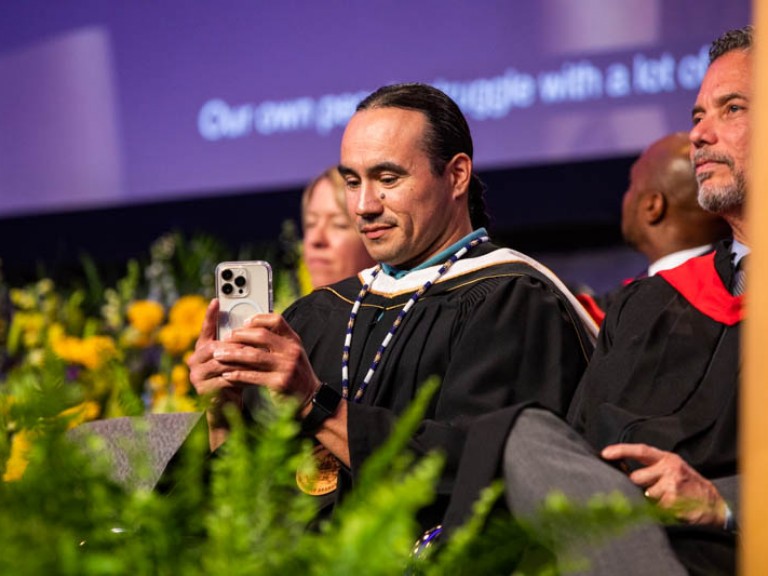 Honorary degree recipient Michael Linklater taking a cell phone picture