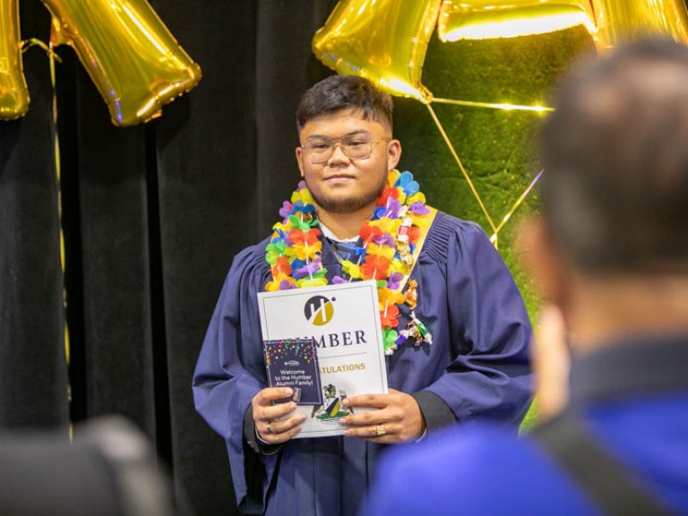 Graduate holding certificate for photo