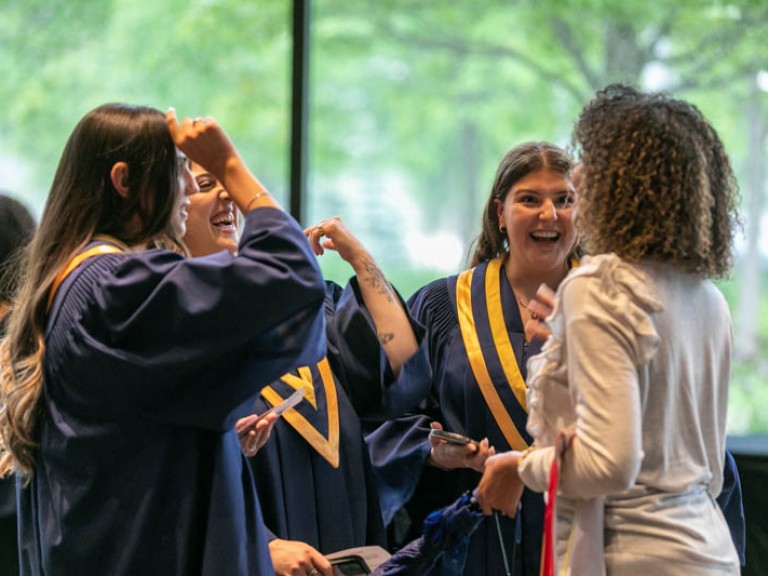 Three graduates and ceremony guest talking