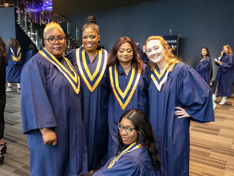 Five graduates posing for photo