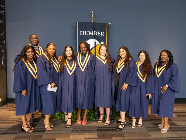 Nine graduates posing for photo
