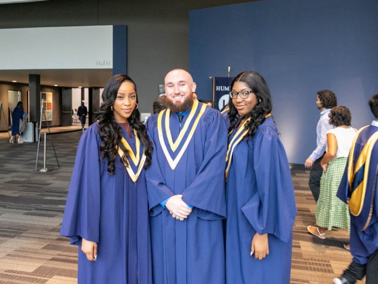 Three graduates posing for photo