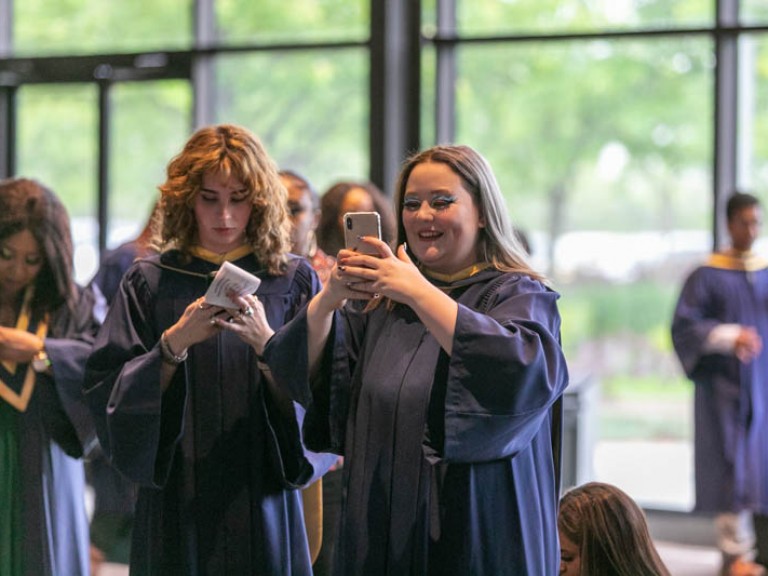 Graduate taking a photo on cell phone