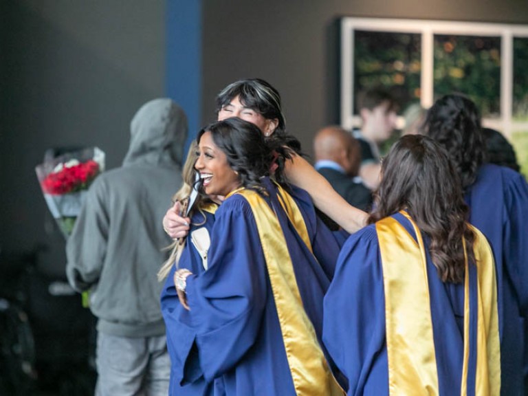 Two graduates hugging