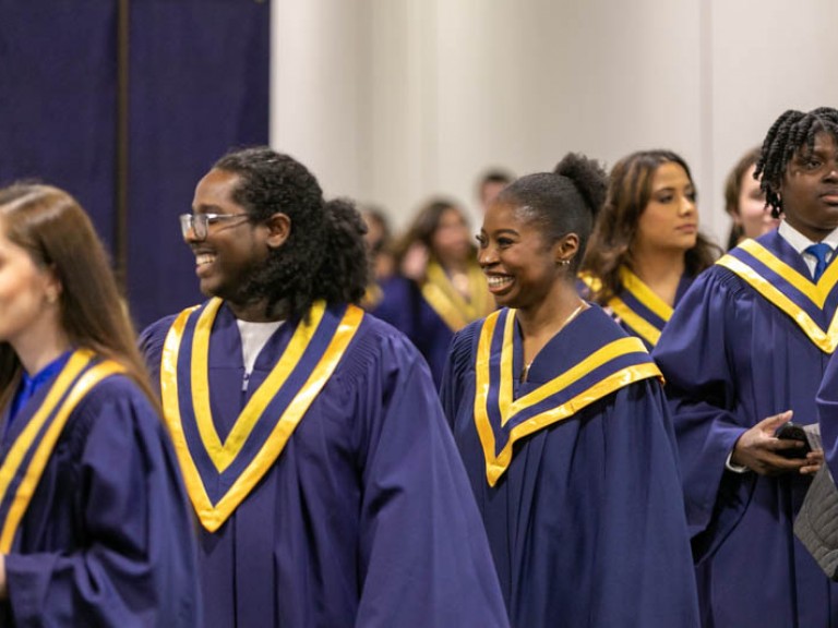 Smiling graduates proceeding in a line