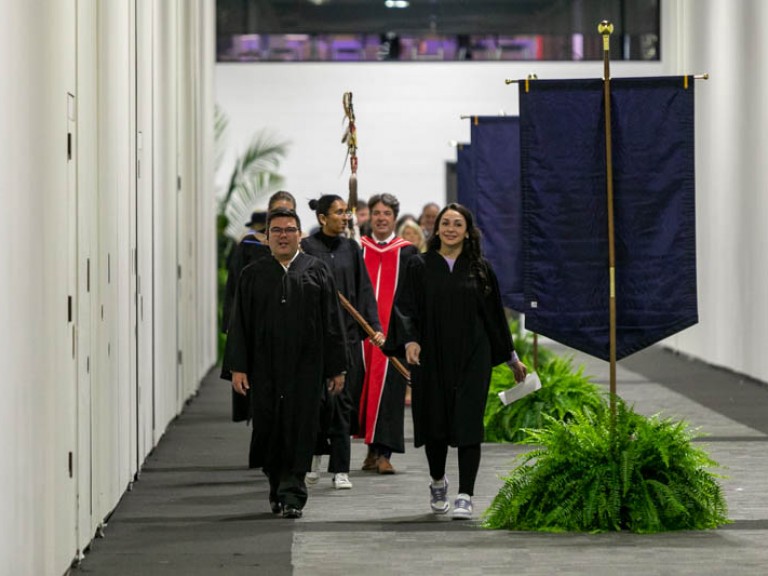 Faculty proceeding down hall