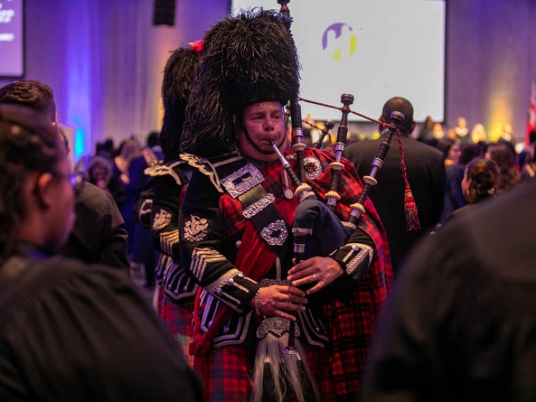 Musician in Scottish regalia plays the bagpipes