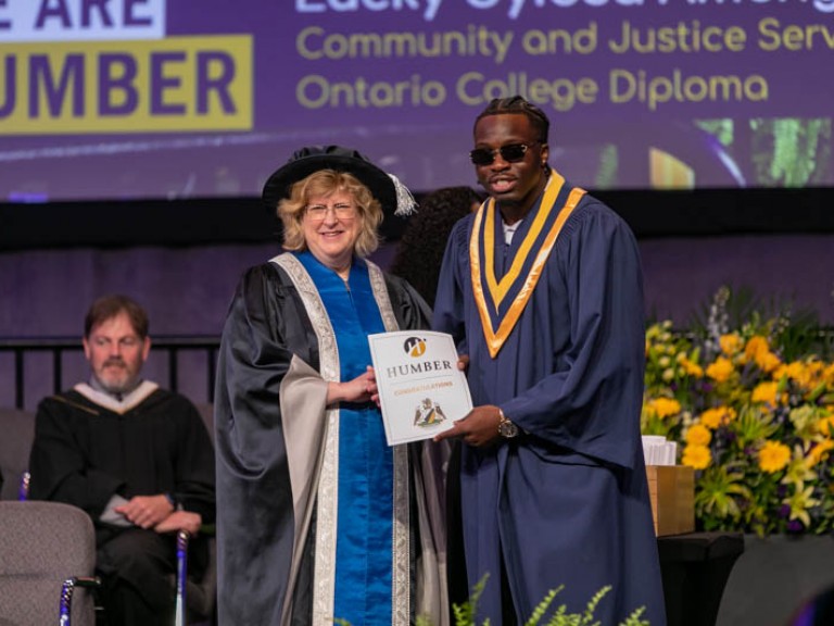 Humber president on stage with graduate