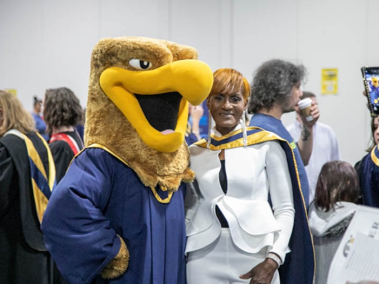 Person poses for photo with Humber mascot