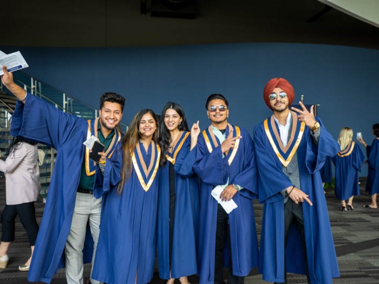 Five graduates posing for photo