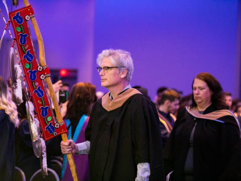 Faculty member carries Indigenous banner into ceremony