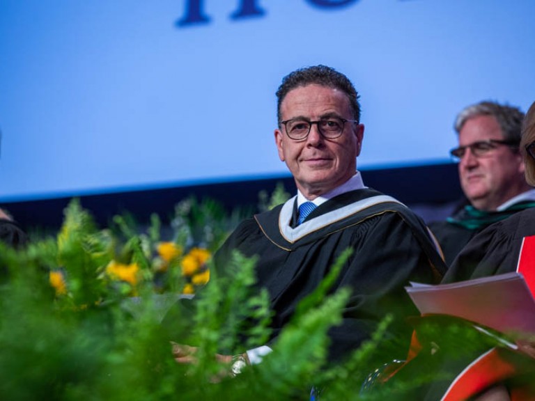 Honorary degree recipient Anthony Longo on stage looks at camera