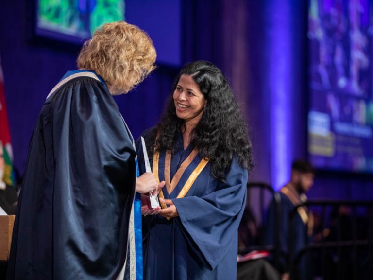 Graduate on stage smiling at Ann Marie Vaughan