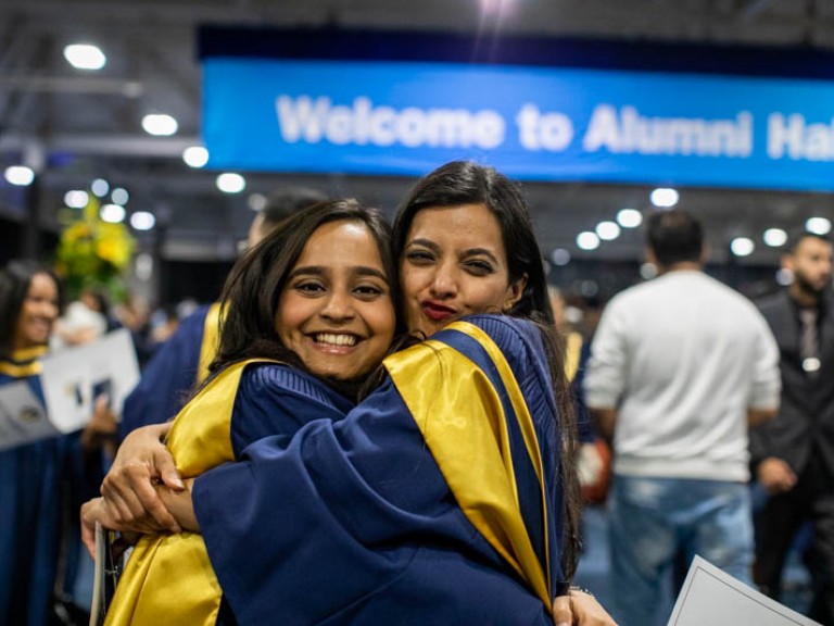 Two graduates hugging