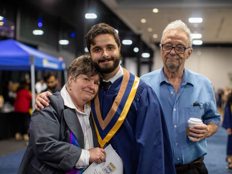 Graduate hugging family member for photo