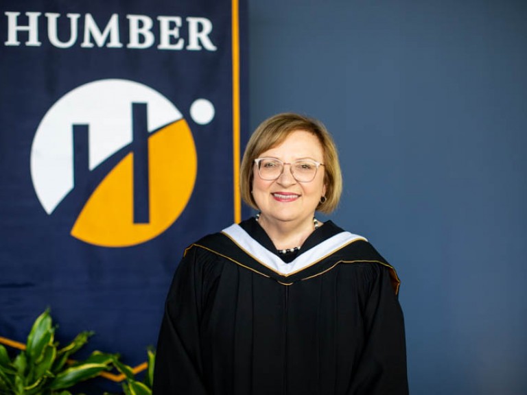 Honorary degree recipient Lana Payne in front of Humber flag