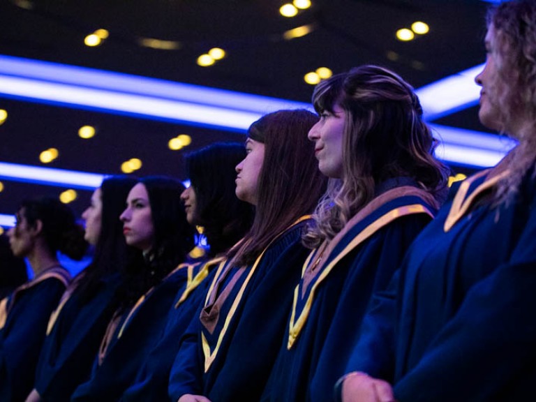Row of graduates looking off camera