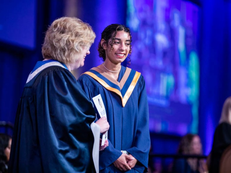 Humber graduate on stage beside Ann Marie Vaughan