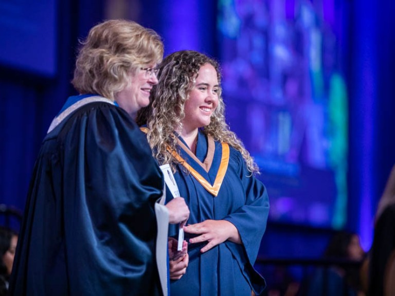 Ann Marie Vaughan and graduate smile for photo