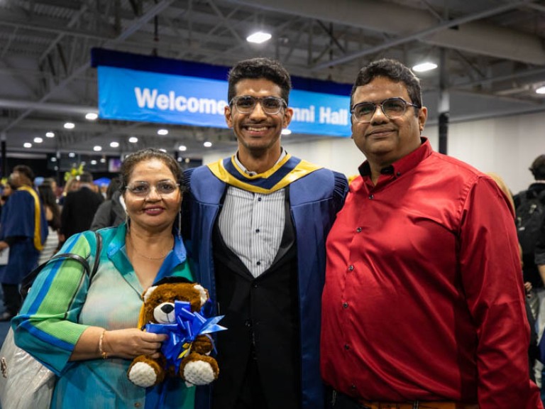 Graduate posing for photo with his parents