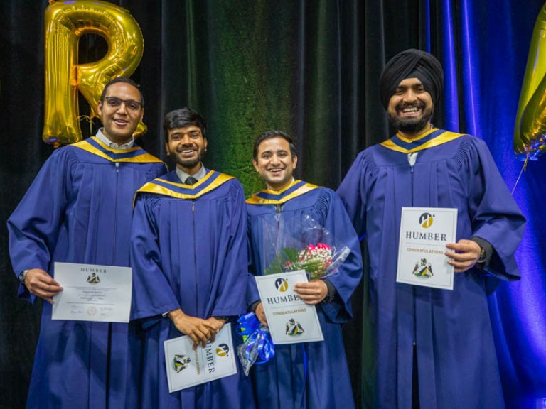 Four graduates smiling for photo