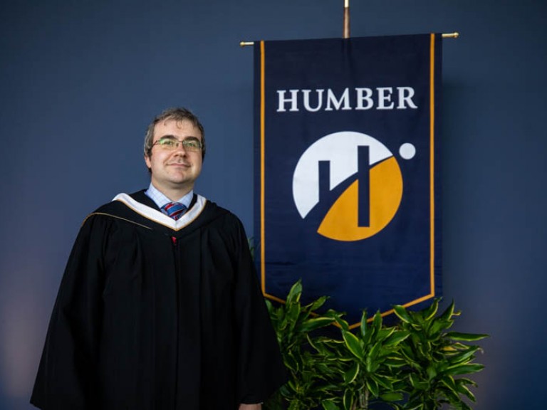 Andrew Monkhouse poses for photo in front of Humber flag