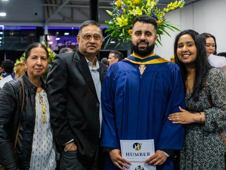 Graduate poses for photo with family