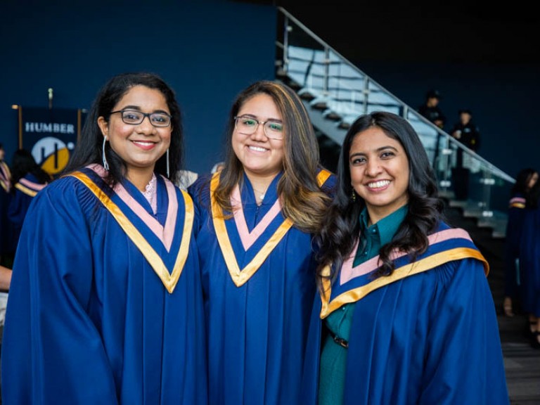 Three graduates smiling for photo