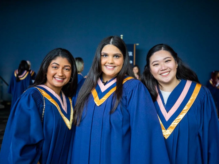 Three graduates smiling