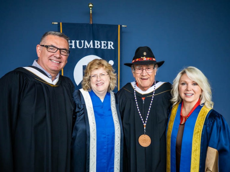 Elder Albert Marshall takes photo with Ann Marie, Jason Seright, and faculty member
