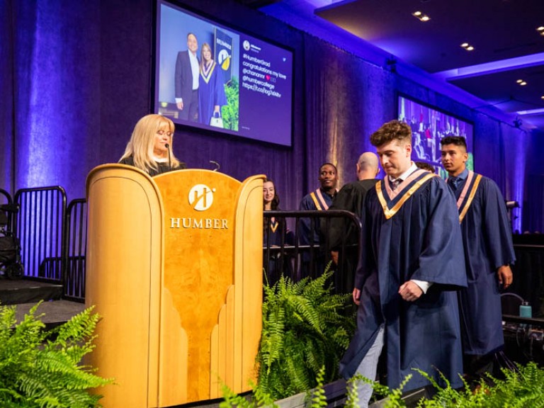Graduate walking in front of podium