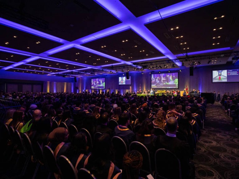 Wide view of ceremony hall with graduates seated
