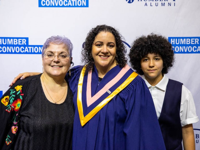 Graduate taking photo with two family members